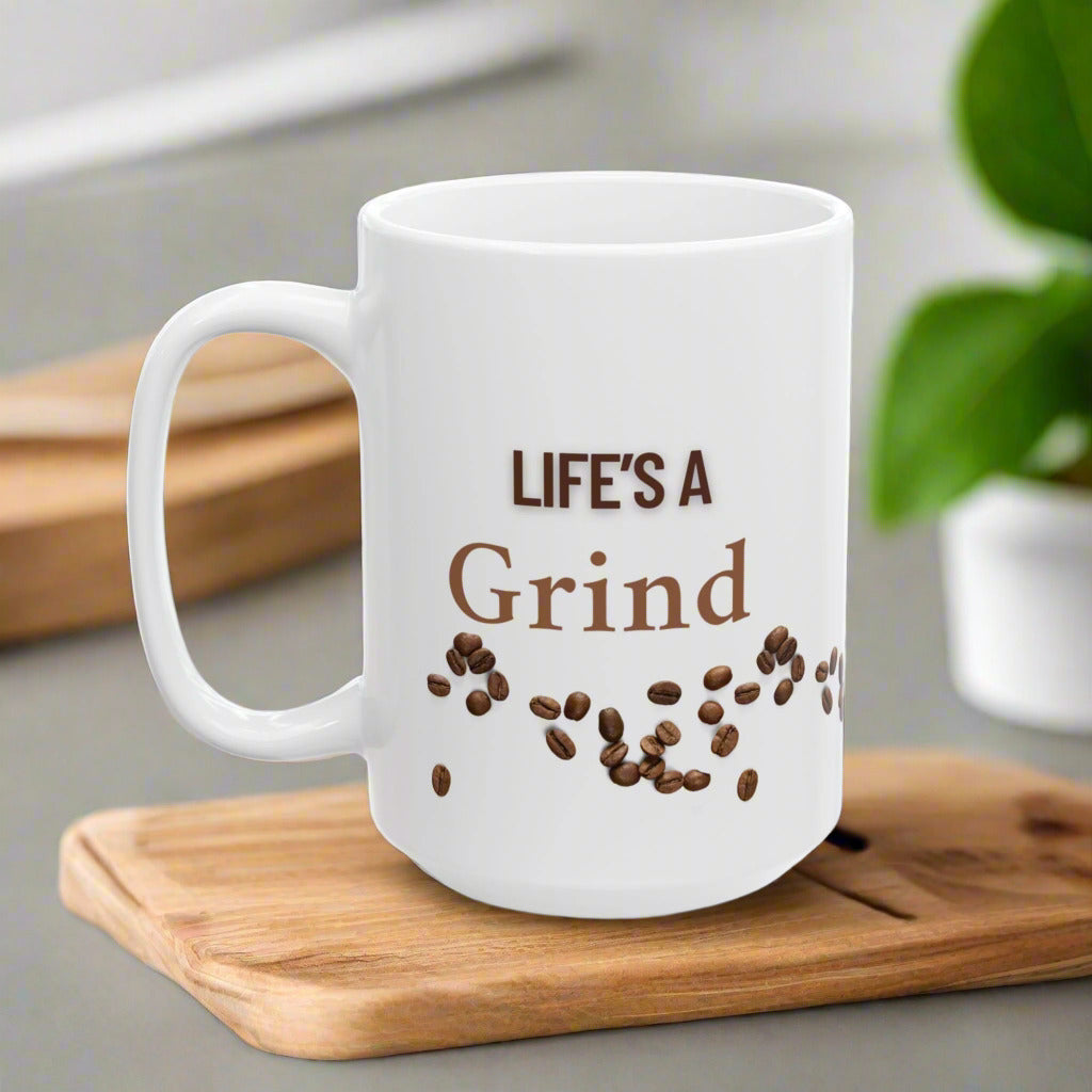 A white ceramic mug with 'LIFE'S A Grind' text and coffee beans scattered around the bottom.