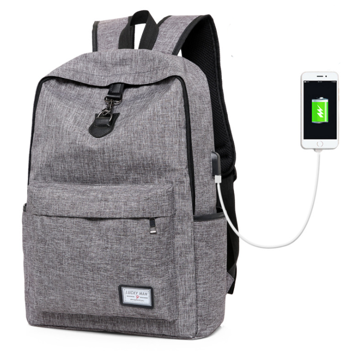 A gray backpack with a front pocket, displayed alongside a smartphone connected to a USB charging cable, indicating the backpack's USB charging capability.