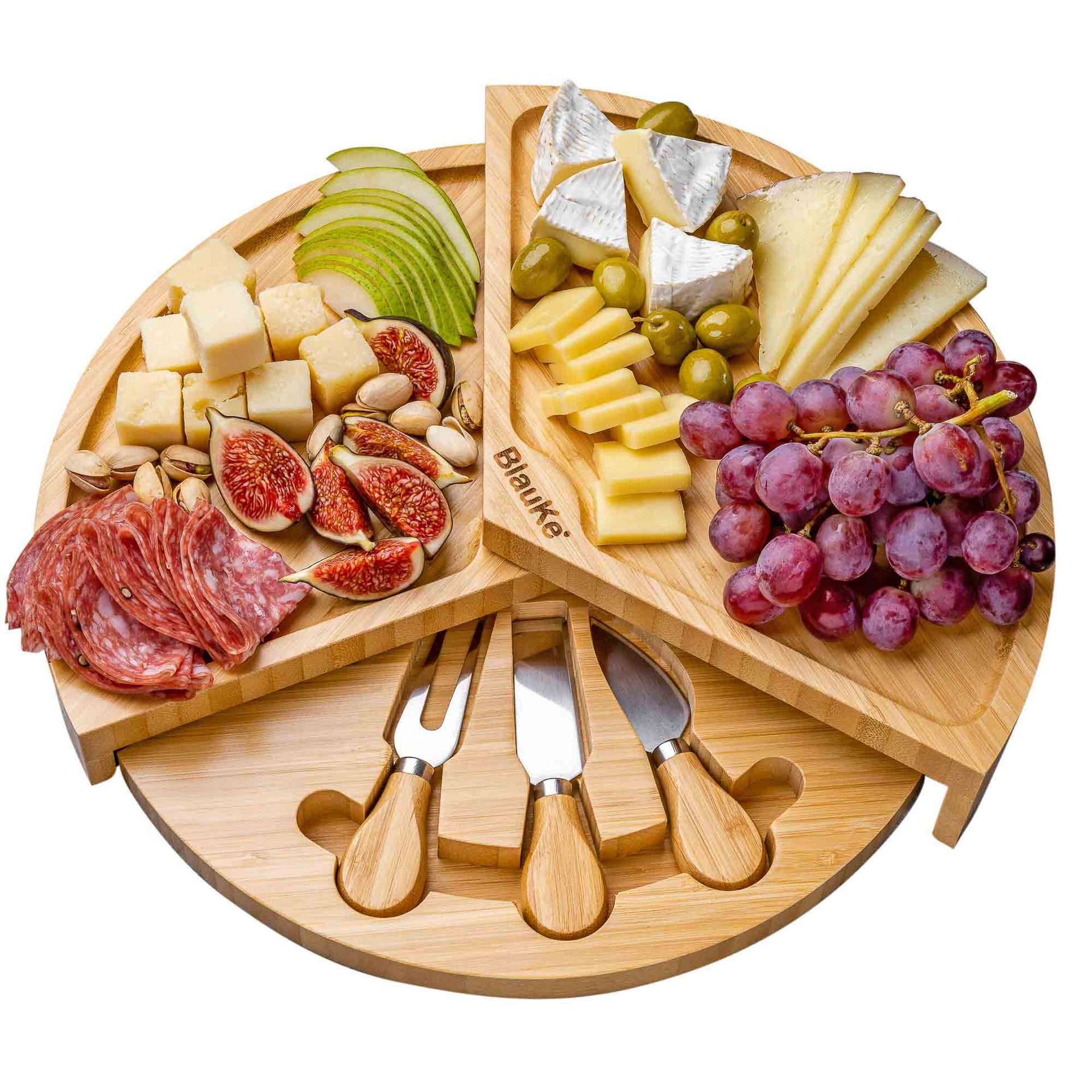 Wooden charcuterie board with assorted meats, cheeses, fruits, and a set of knives on a white background.