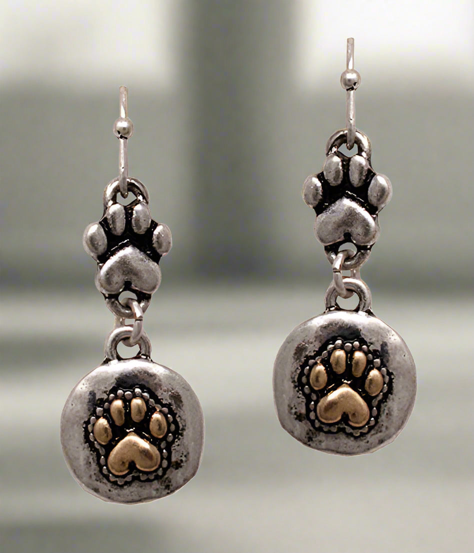A pair of silver-colored paw print drop earrings.