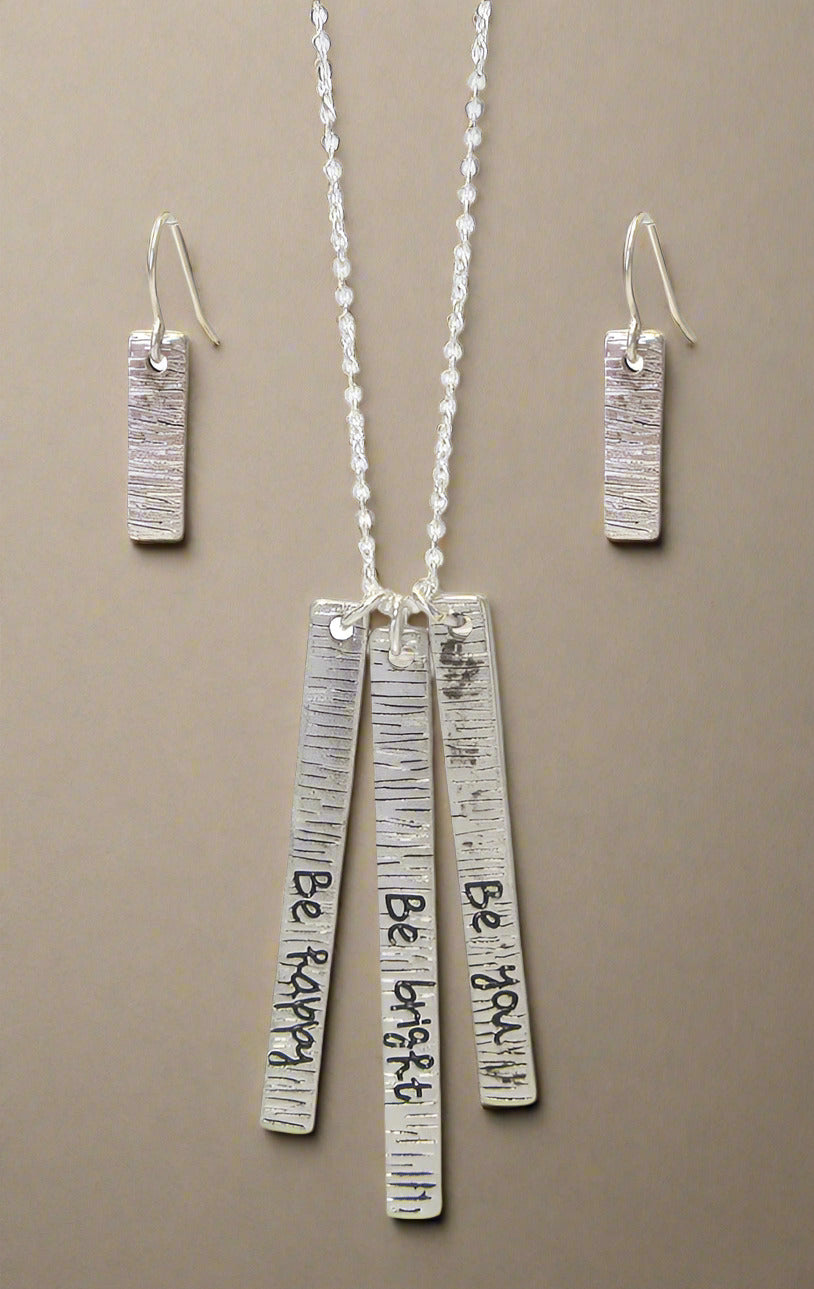 A silver-colored necklace set with a triple bar pendant and matching earrings, displayed against a white background.