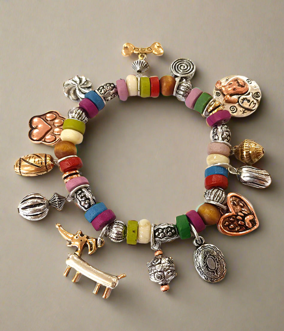 A colorful stretch bracelet featuring a mix of vintage metal charms and beads, including animal charms and bead shapes.