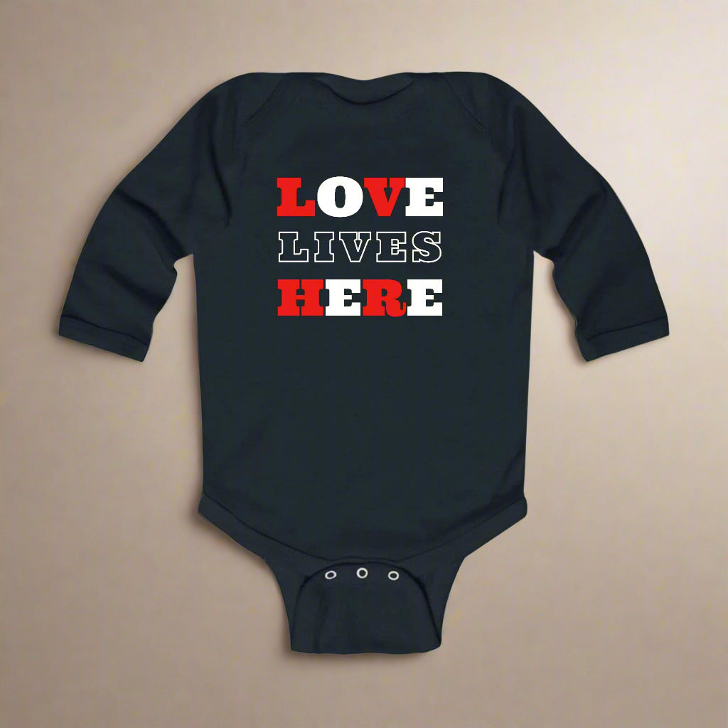 A black long-sleeve infant bodysuit with the text 'LOVE LIVES HERE' printed in red and white.