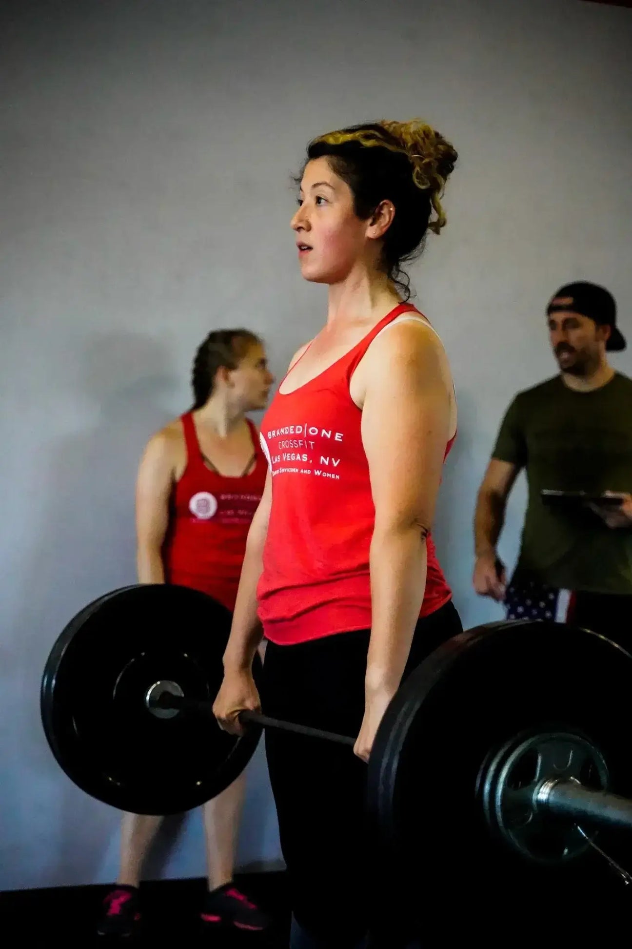 Branded One CrossFit: Fitness with a Mission workout featuring a woman lifting weights.