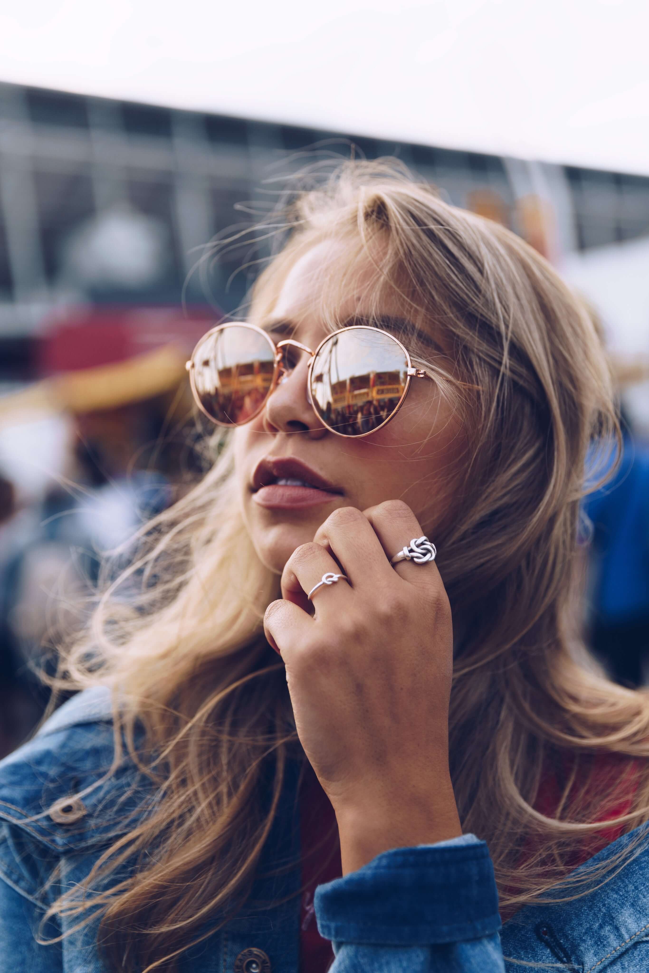 Sandly blonde girl weating unique jewelery and accessories, such as sunglasses and silver rings