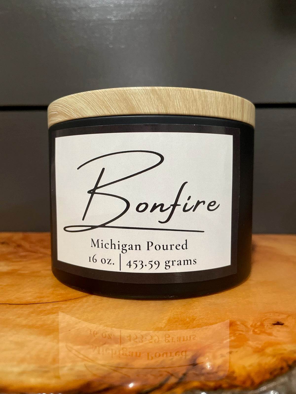 Bonfire 16 oz soy candle in black jar with wooden lid, Michigan poured, minimalist white label design, hand-poured aromatherapy candle with warm smoky fragrance, rustic home décor and gift idea.
