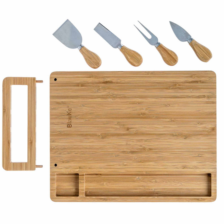 Bamboo cutting board with cheese tools on a white background