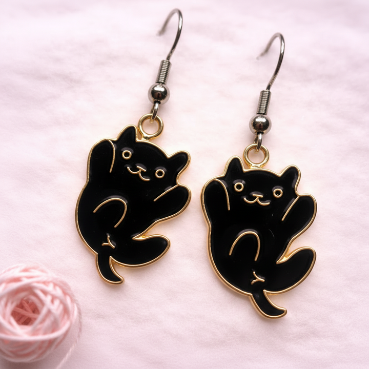 Black cat dangle earrings with gold accents, playful cat design, hypoallergenic jewelry by Sonya Lee.