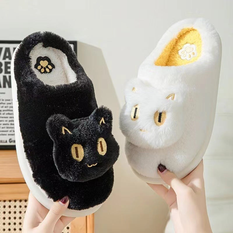 White cotton cat slippers with cute feline face design held in hand