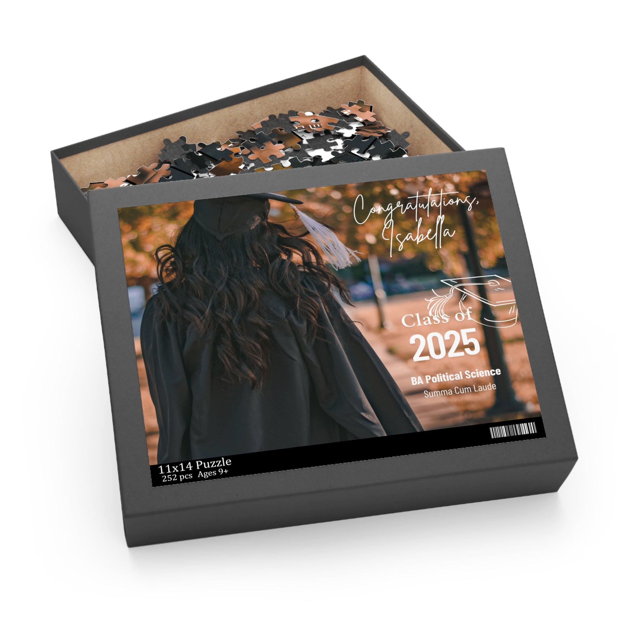 Customized jigsaw puzzle in a box with the image of a graduate in a cap and gown, titled 'Congratulations Isabella, Class of 2025'.