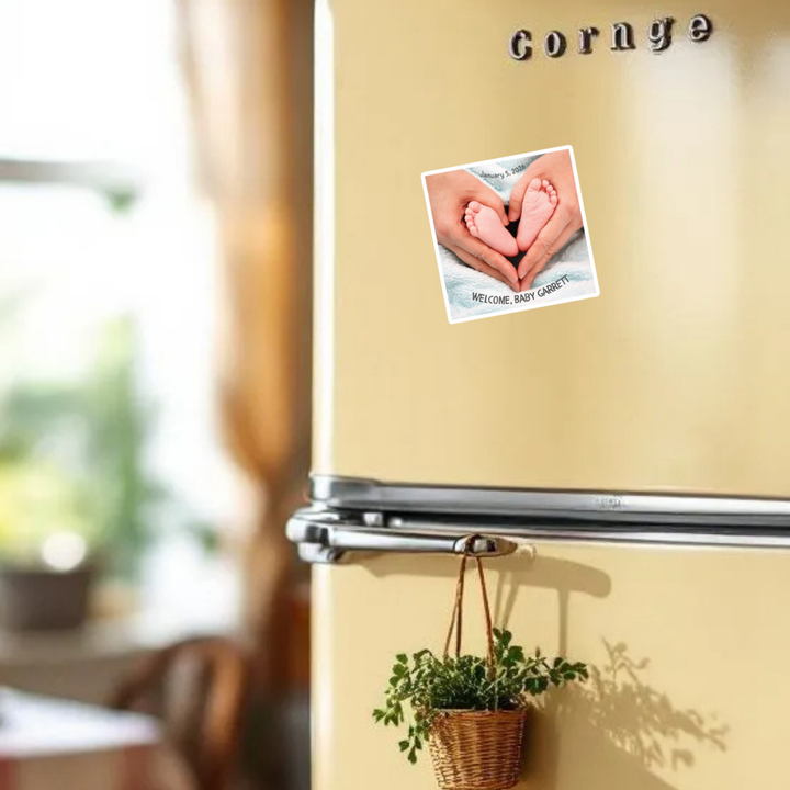 Beige refrigerator with a plant and baby announcement photo magnet in a kitchen setting