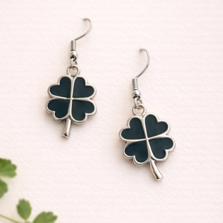 Pair of four-leaf clover earrings on a white background