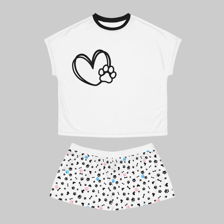 White crop top with black heart and paw print design, paired with a skirt featuring multicolored paw prints on a white background.