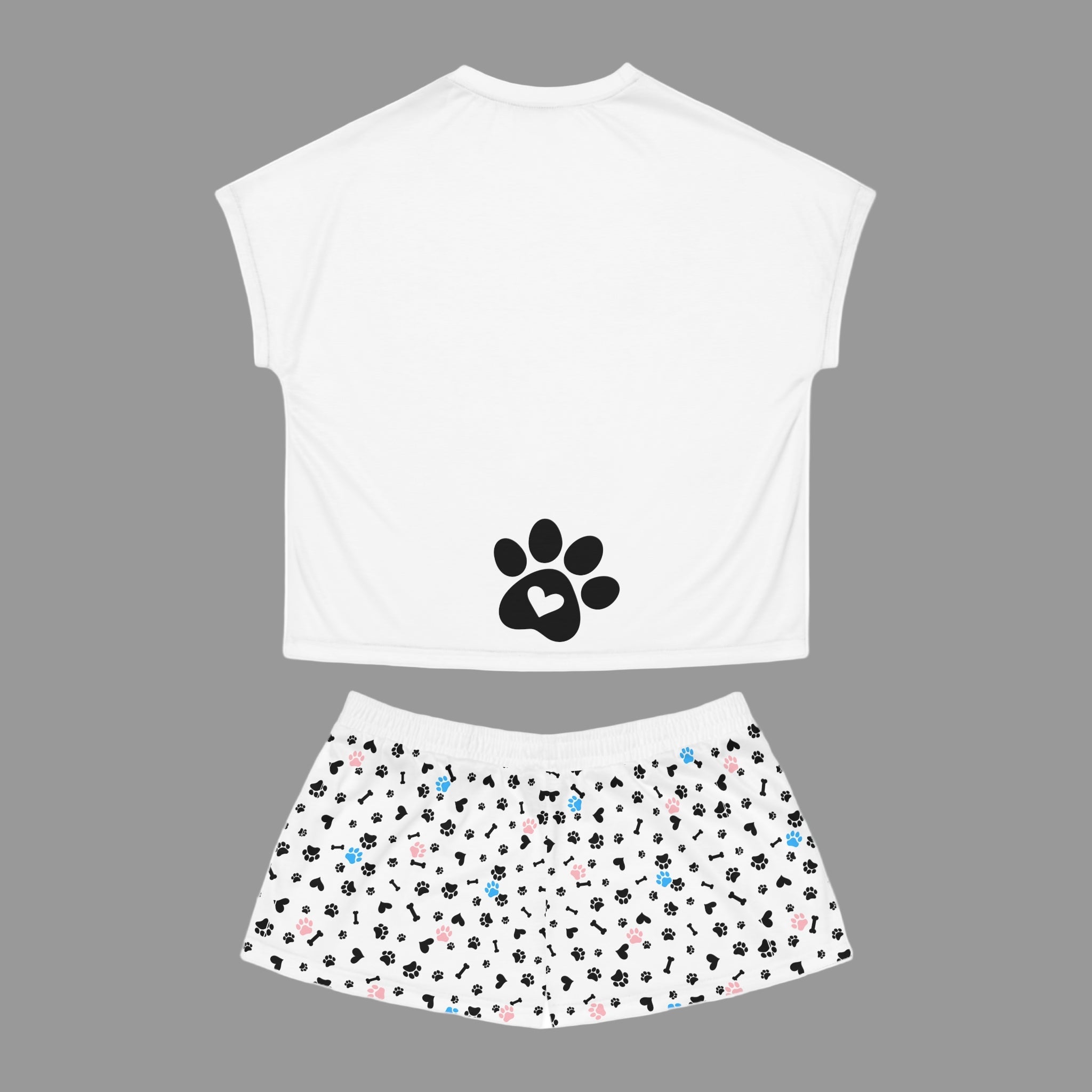 White sleeveless top with black paw print design and patterned shorts on a white background