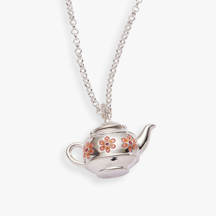 Silver teapot-shaped pendant with floral designs on a chain against a white background