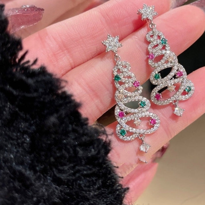 Decorative earrings held in a hand with a blurred background