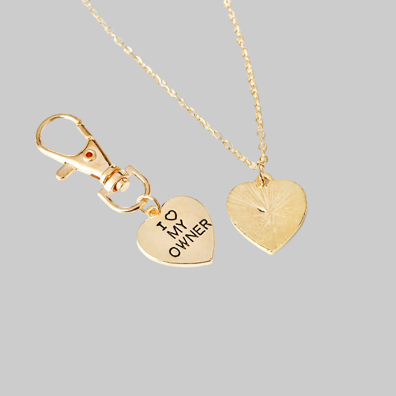 Gold heart-shaped necklace with 'I love my owner' tag on a white background