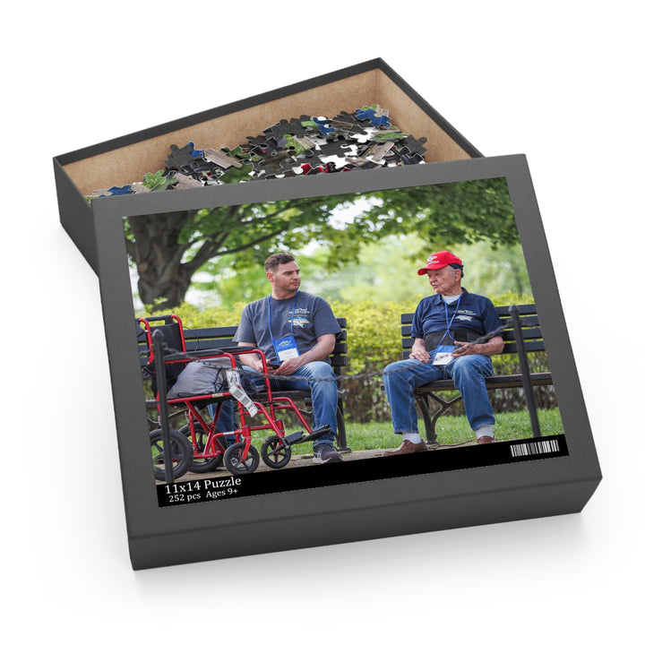 A custom jigsaw puzzle featuring two individuals sitting on a bench with a dog, packaged in a gift-ready box with the puzzle pieces visible inside.