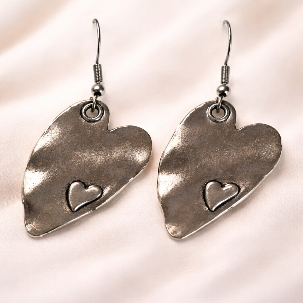 Handcrafted silver heart dangle earrings with subtle inset heart detail, hypoallergenic and lead-free