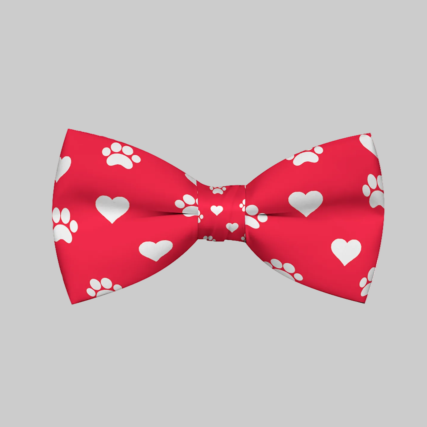 Red bow tie with white heart and paw print patterns on a white background