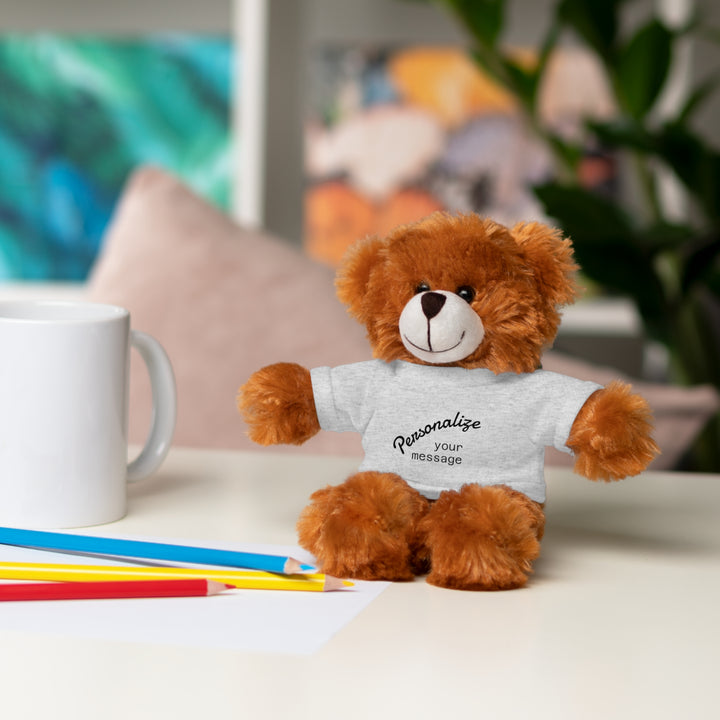 Personalized stuffed animal gift cuddly bear with customizable shirt on a table with colorful pencils and mug