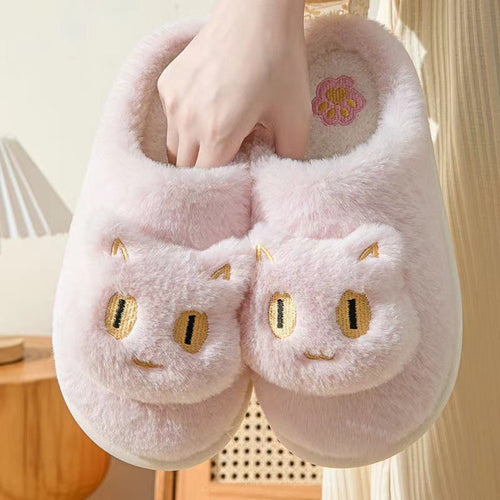Pink cat slippers with plush construction displayed on carpet.