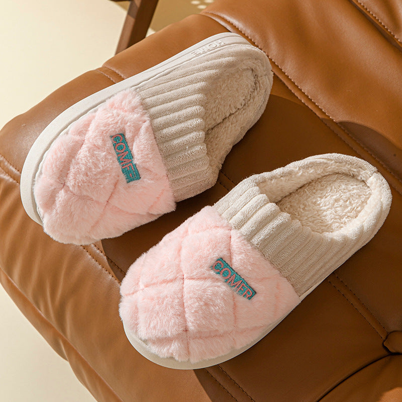 Pair of pink slippers with fluffy texture on a brown surface