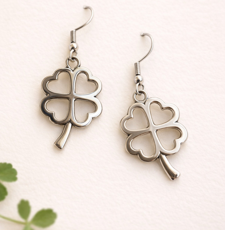 Silver four-leaf clover earrings on a light background
