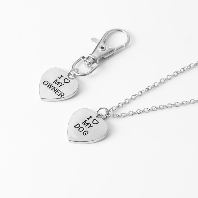 Silver heart-shaped pendant necklace with 'I love my dog' and 'I love my owner' text on a white background