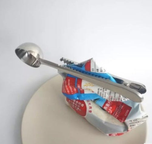 Silver coffee scoop with integrated bag clip sealing coffee pouch