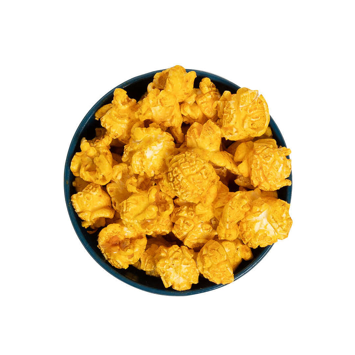 Bowl of Stevie G’s Gourmet Jalapeno Cheddar Popcorn with fluffy yellow kernels in teal bowl viewed from above