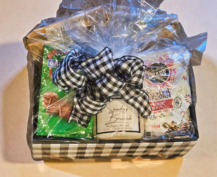 Tea and candle Gift basket with a checkered ribbon on a white surface