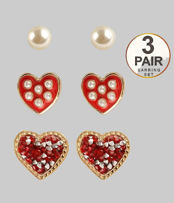 Set of three pairs of heart-shaped earrings with red, pearl, and gold designs on a white background.