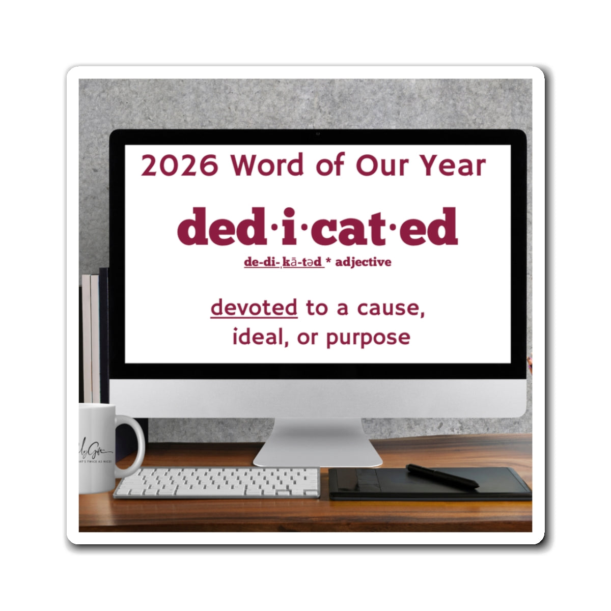 Computer monitor displaying '2026 Word of Our Year: dedicated' on a desk with a mug and keyboard.