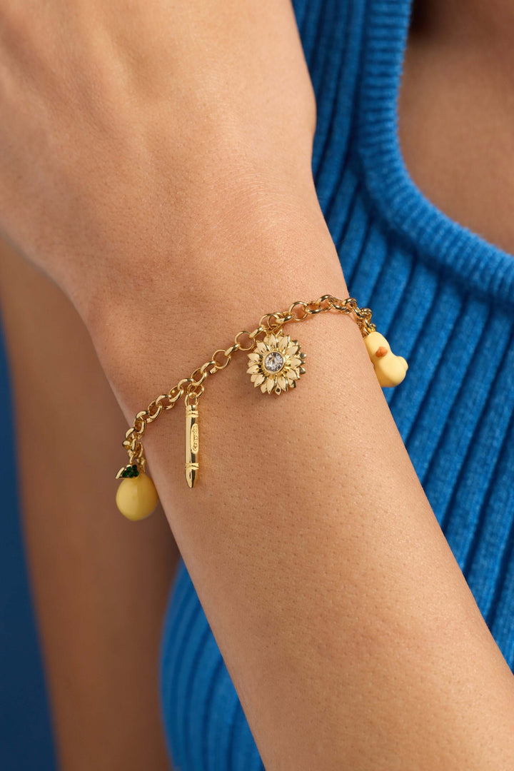 Crayola charm bracelet with duck sunflower bee worn on a wrist, featuring colorful charms and a gold chain.
