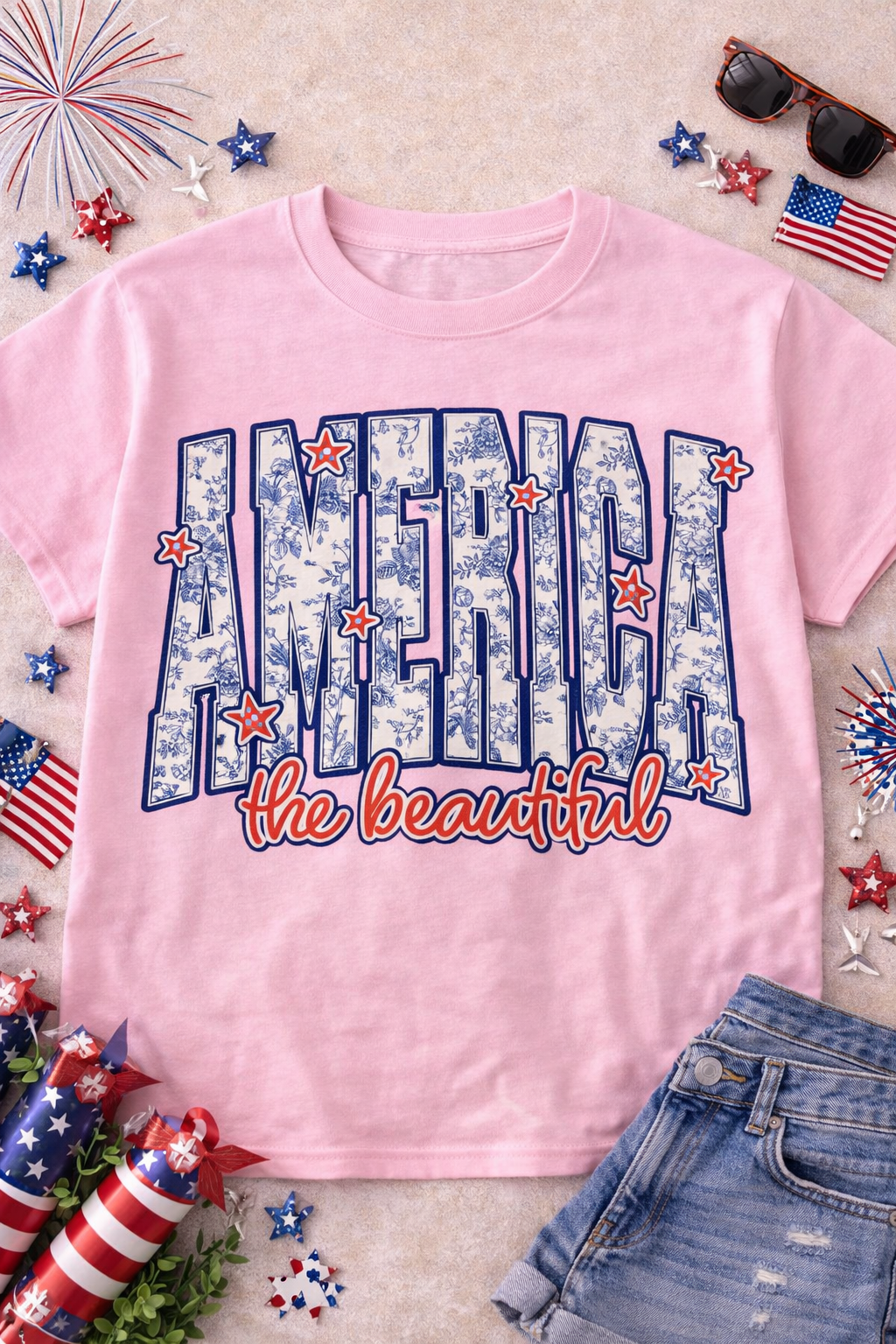 Patriotic graphic t-shirt for women featuring vibrant 'America the Beautiful' design on a pink background.