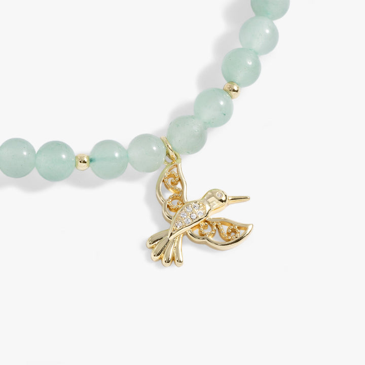 Hummingbird gemstone bolo bracelet featuring green aventurine beads and a gold hummingbird charm.