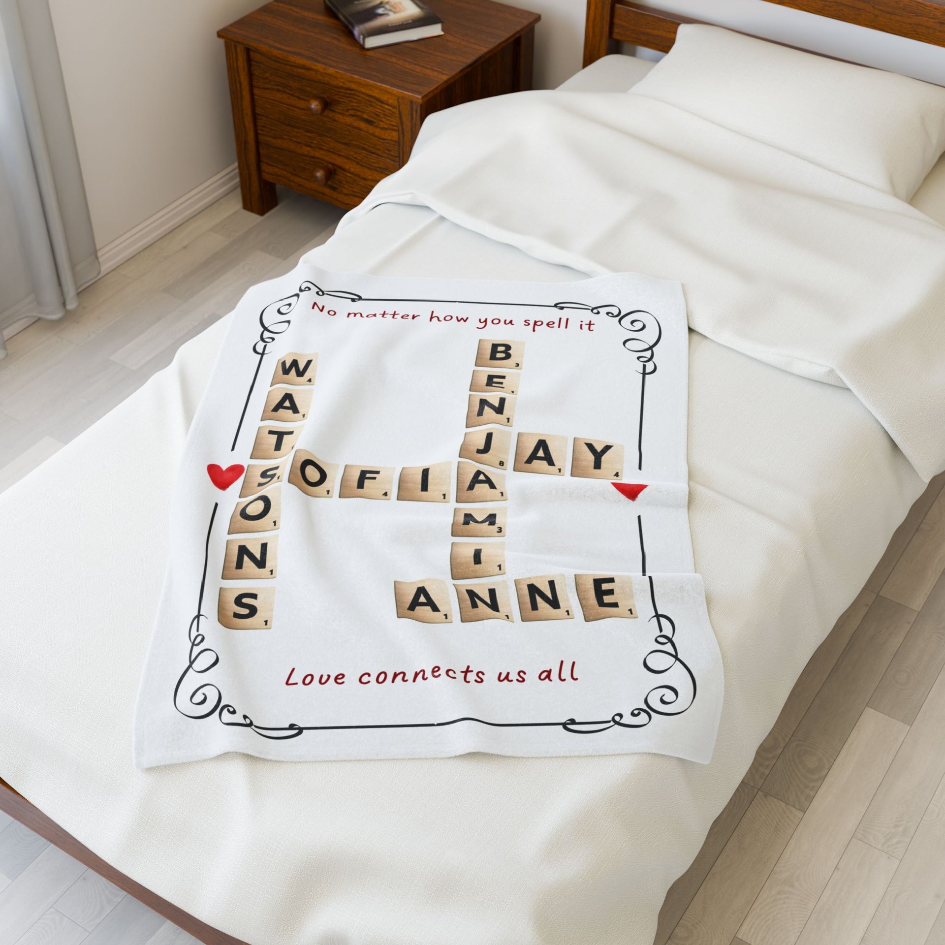 Personalized family name blanket with Scrabble-style crossword layout draped on a bed