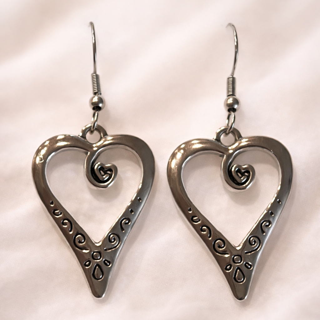 Heart-shaped silver earrings on a light background