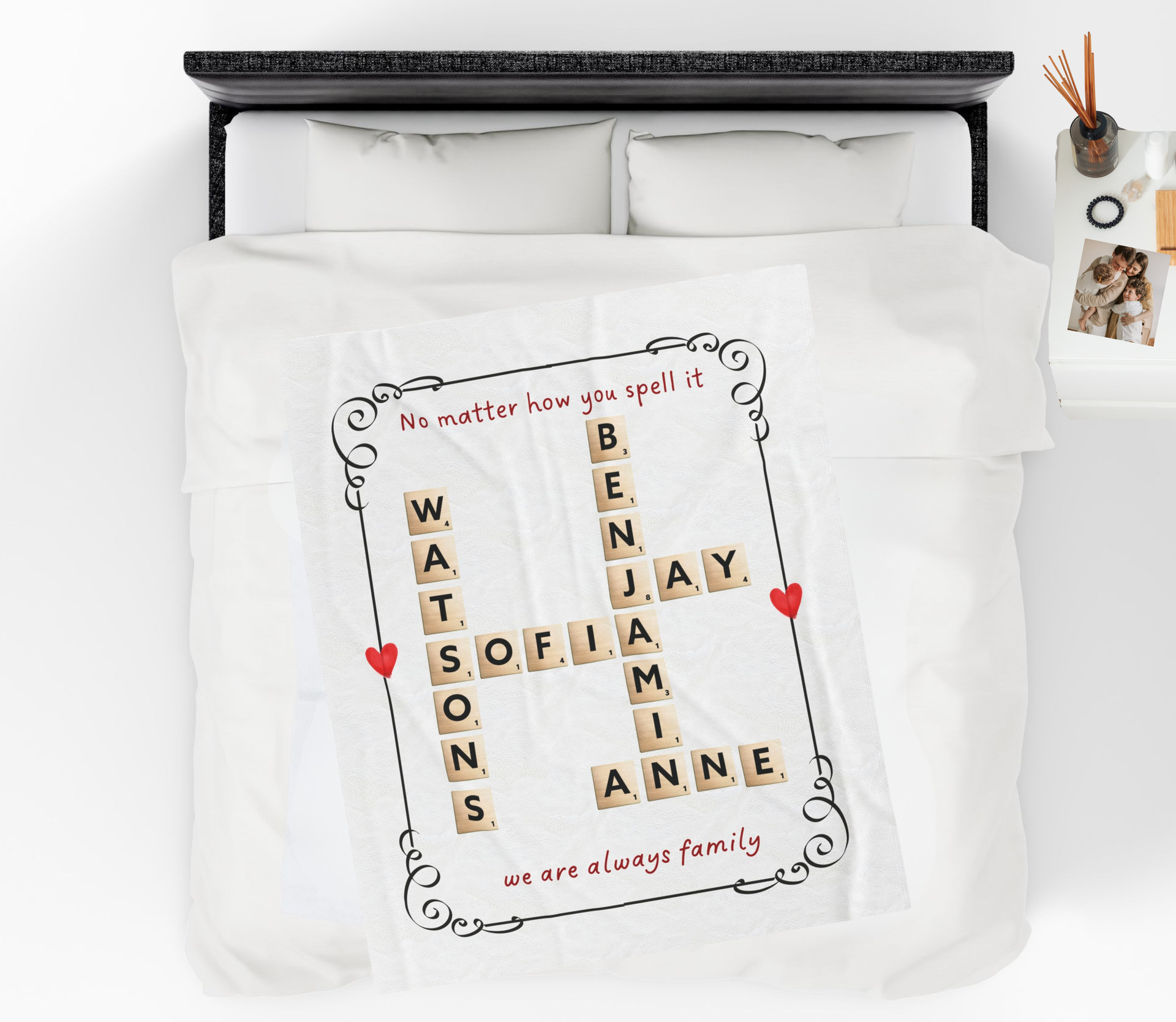 Personalized family name blanket with Scrabble-style letter tiles arranged to form names, displayed on a bed