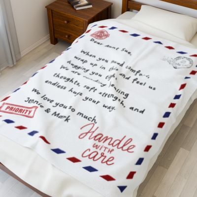 Personalized message blanket with airmail design displayed on a bed, featuring a heartfelt letter-style note