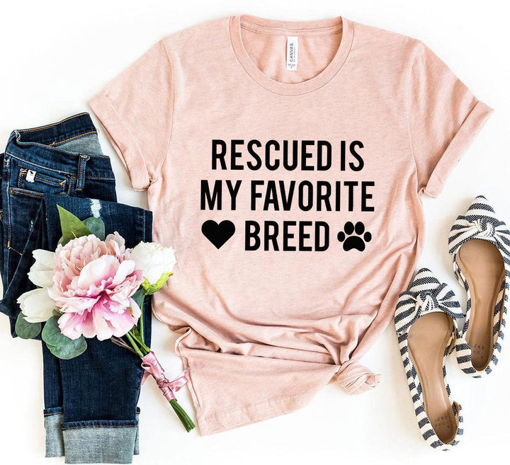 rescued is my favorite place t-shirt displayed with jeans, floral arrangement, and shoes in a stylish flat lay.
