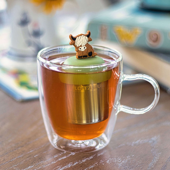 Tea Infuser Highland cow floating in a cup of brewed tea, featuring a cute design and fine mesh strainer for loose leaf tea.