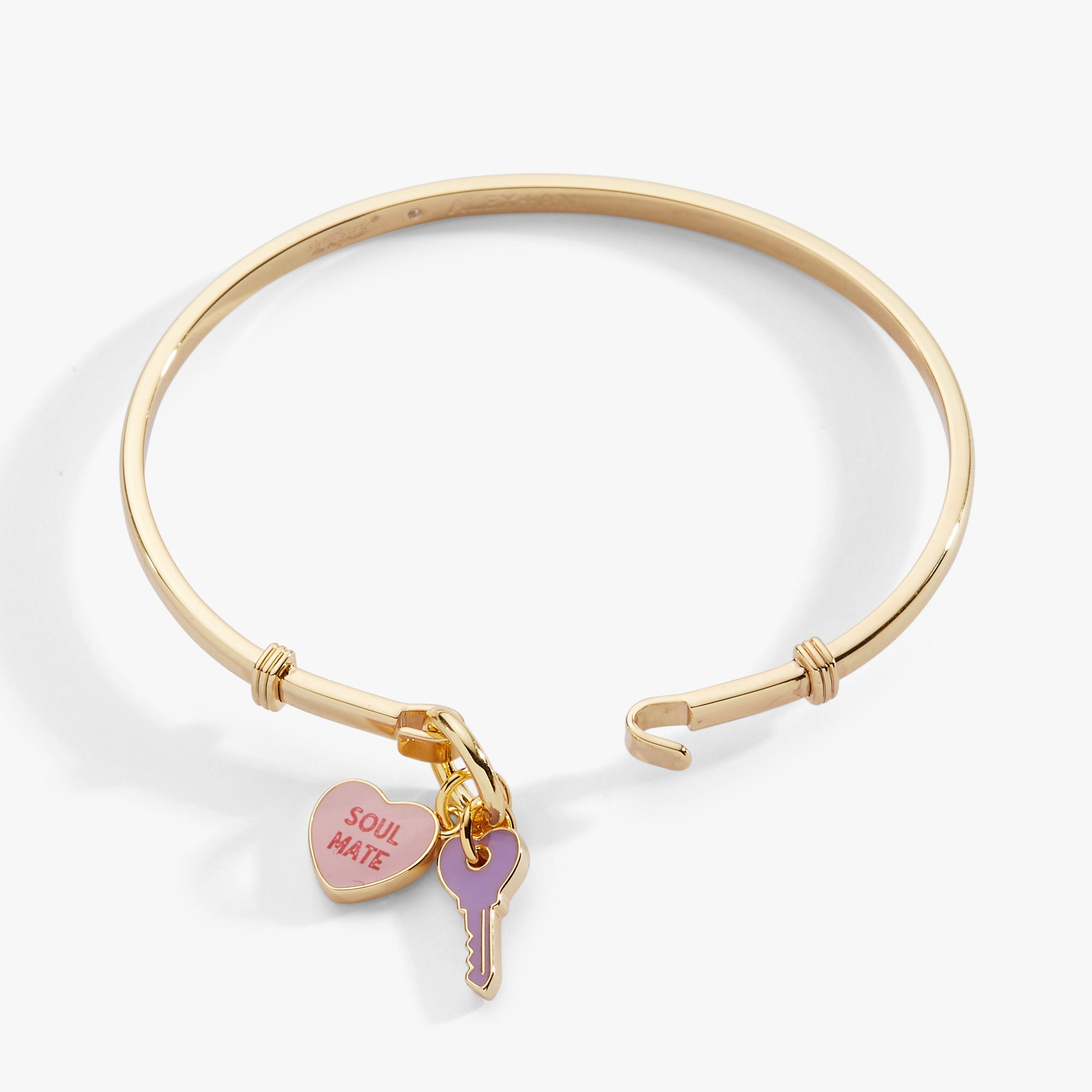 Gold bangle with heart-shaped 'Soul Mate' charm and purple key charm on a white background