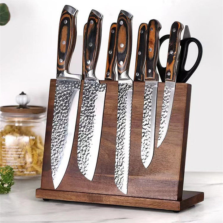 Set of six knives with wooden handles in a wooden stand on a white surface.