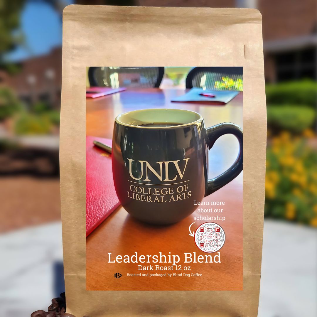 UNLV College of Liberal Arts Leadership Blend coffee, 12 oz dark roast bag featuring UNLV mug on conference table, roasted by Blind Dog Coffee, supporting university scholarships and leadership programs.
